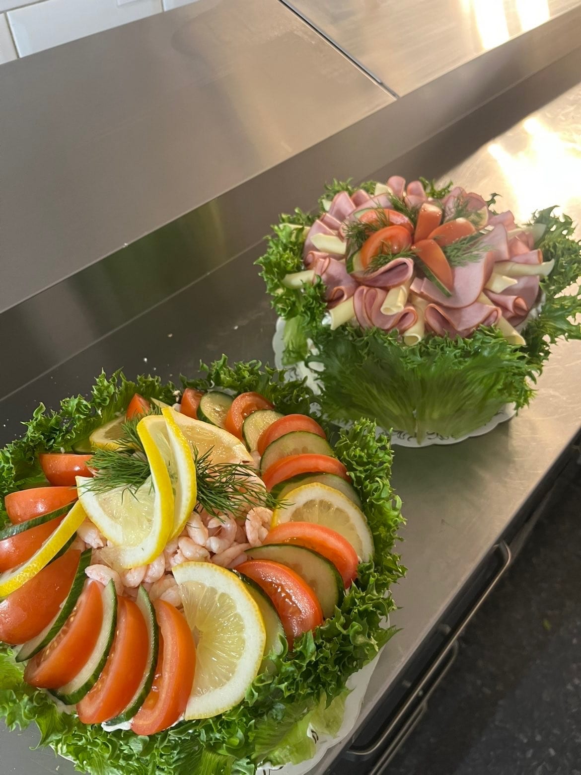 Två smörgåstårtor – en med räkor, citron och dill, en med rullad skinka och ost